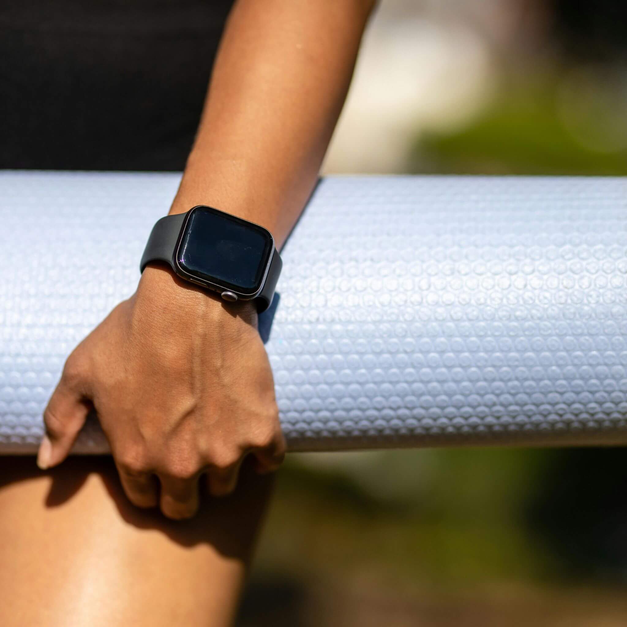 Lady Wearing Apple Watch With Black Silicone Watch Band Whilst Carrying Yoga Mat