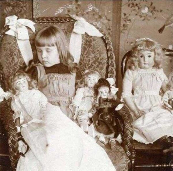 Photo of a beautiful and well dressed dead girls with with her dolls, it was custom to take dead person's photo